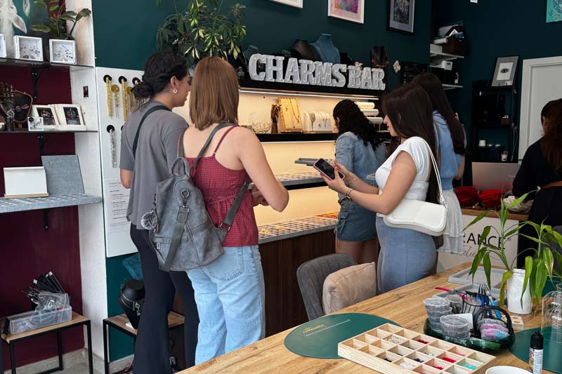 Visitors at Charm Bar Prague browsing through Charms collection